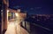 Rooftop patio with glass balustrade and city view at night