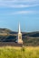 Rooftop and steeple of a church with mountain and pale blue sky background