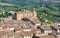 Rooftop view on Tuscany town and fields. San Gimignano medieval city houses and natural landscape, Italy