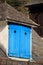 Rooftop window with blue wooden shutter of a mountain hut, pyrenees, south france