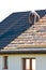 Rooftop worker installing new metal tiles on a house