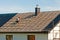 Rooftop worker installing new metal tiles on a house