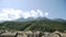 Rooftops of ski resort with mountains in background. Panorama of forest-capped mountain peaks on morning. Bright morning