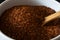 Rooibos Tea Leaves Close Up in White Bowl with Wooden Spoon