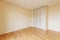 A room with beautiful light pine wood floors with a custom wood cabinet with white doors, cream painted walls and a plaster molded