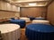 A room with blue and white circular tables with forks and knives