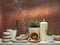Room decoration with scented incense stick, candle, rocks and cactus on white shelf against old brick color wall