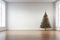 A room devoid of furniture, only a Christmas tree decorates the space
