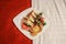 Room Service - Square plate with bacon tomato and lettuce sandwiches and chips and salad sitting on an attractively made up bed -