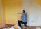 A room where a man cleans a wall, removing old wallpaper, washing a wall, repair concept