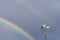 Rooster weather vane with double rainbows and gray sky backgroundy sky