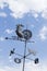 Rooster Weathervane Against Blue Sky and White Clouds