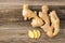 A root of ginger with sliced pieces on a wooden background