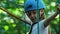 Rope adventure in the park - a little girl in helmet moving over the rope bridge on high