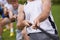 Rope, arm pull and men hands with teamwork, tug of war and fitness outdoor on sport field. Training, workout and athlete