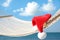 Rope hammock with Santa`s hat on beach, closeup. Christmas vacation