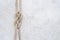Rope knot on a white textured concrete background