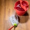 rope mop near bucket with water on wooden floor