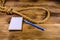 Rope with noose for the suicide, blank notepad and pen on wooden background