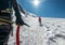 Rope team descending Mont Blanc Monte Bianco summit 4,808m dressed mountaineering clothes walking by snowy slopes with ice axe