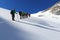 Rope team mountaineering with crampons on glacier Sexegertenferner towards Sexegertenspitze and mountain snow panorama with blue