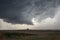 A rope tornado funnel dissipates underneath the updraft of a supercell thunderstorm.