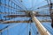 Ropes to control the sails, details of the device of the yacht, the mast of the sailing ship against the blue sky