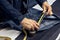 ropped image of tailor makes measurements of jeans with a meter at sewing workshop.