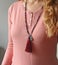 Rosary mala 108 beads from natural stones sapphire are worn on a girl in a rose shirt. Author`s jewelry from natural stones,