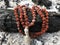 Rosary prayer beads on the ash cinder background. Rudraksha. Mala. Mantra. 108 beads.