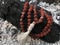 Rosary prayer beads on the ash cinder background. Rudraksha. Mala. Mantra. 108 beads.