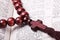 Rosary with a wooden cross lying on open Bible