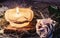 Rose, dry hay and a candle on a table