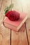 Rose flower on book over wooden background