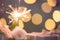 Rose flower, gift box, sparkler, on wooden table with bokeh background