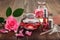 Rose flower, infused water and essential oil or rose blend bottle, flavored water in a spray bottle, pink clay powder.