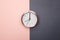 Rose gold clock on pastel pink and grey background. minimal idea