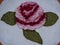 Rose Parade Logo in rose petals of red and pink with green peas