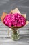 Rose peony Misty Bubbles. Bouquet flowers of pink roses in glass vase on dark grey rustic wooden background. Shabby chic