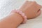 Rose quartz bracelet on woman wrist.