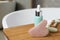 Rose quartz gua sha tool, natural face roller and cosmetic product on wooden bath caddy. Space for text