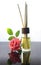 Rose scented oil bottle with wooden sticks on white