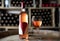 Rose wine bottle with a filled wineglass on a barrel in a cellar