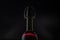 Rose wine. Red wine in bottle and metal opener on cork. Dark background