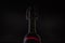 Rose wine. Red wine in bottle and metal opener on cork. Dark background