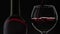 Rose wine. Red wine pour in wine glass over black background. Slow motion