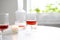 Rose wine in trendy ribbed wineglasses and decanter on white table