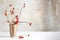 Rosehip branches in a stoneware vase on a white table in front o