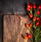 Rosehips on old wooden board, top view, autumn background