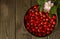 Rosehips in vintage brass bowl and a branch of rosehip bush with a pink rosehip flower